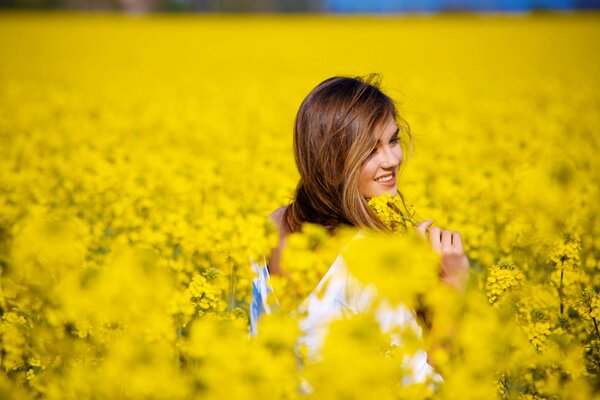 Ragazza sorridente sul campo con denti di leone