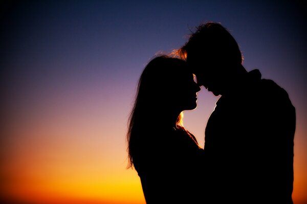 La fuerza de una pareja enamorada en el fondo de una hermosa puesta de sol