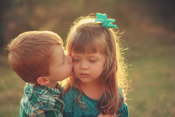 Un niño besa a una niña con un estado de ánimo triste