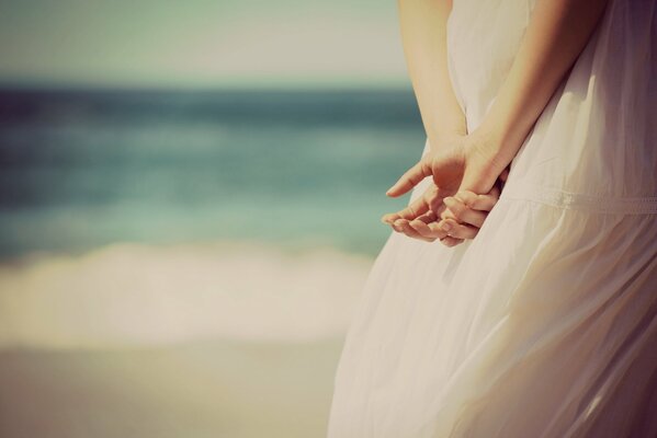 Hands of a girl in a white dress