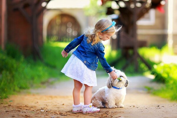 Street, summer, a little girl walks with a dog