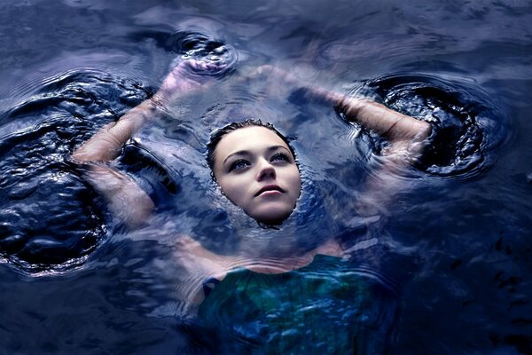 Ein interessantes Mädchen schwimmt auf dem Wasser