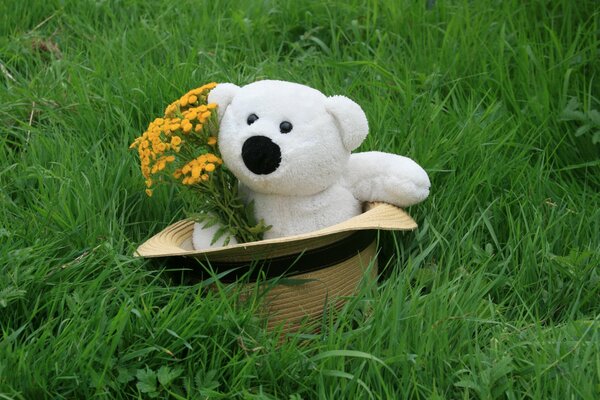 Oso de peluche blanco con flores en un sombrero