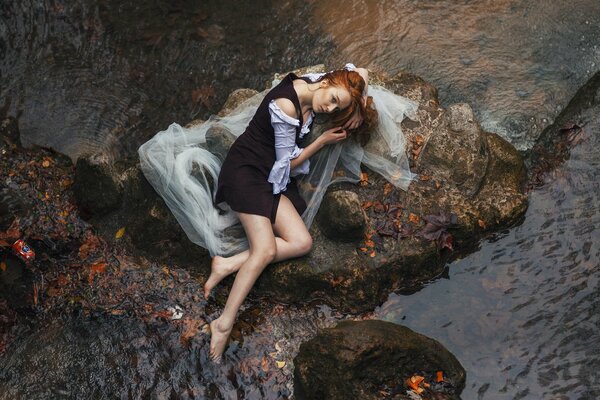 Girl on the rocks on the river bank