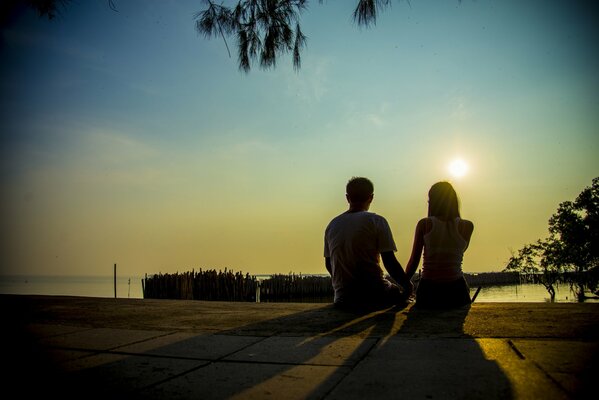 Para kochanków na tle zachodu słońca nad jeziorem