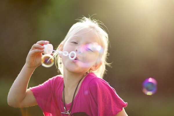 The girl blows soap bubbles