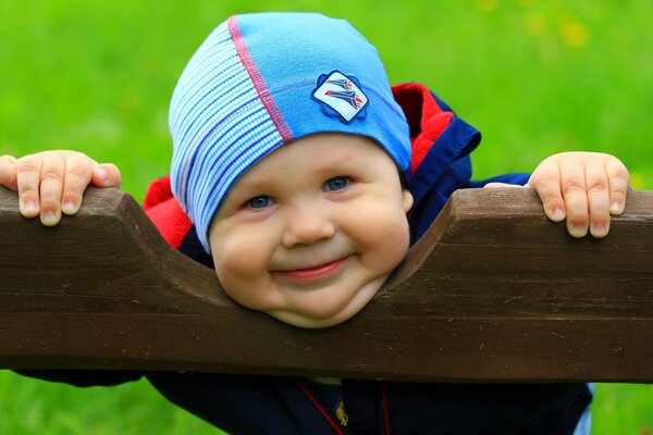 Niño sonriente en un banco del parque