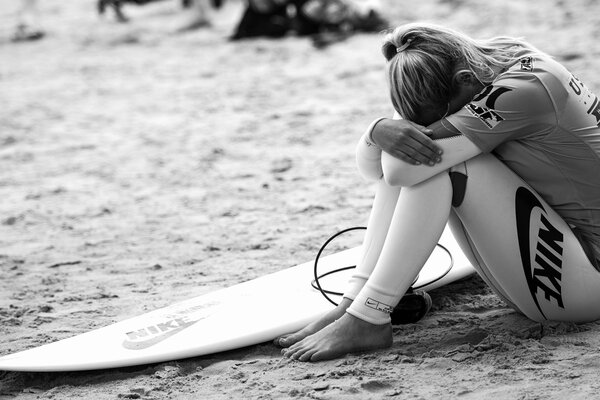 Fille bouleversée avec planche de surf