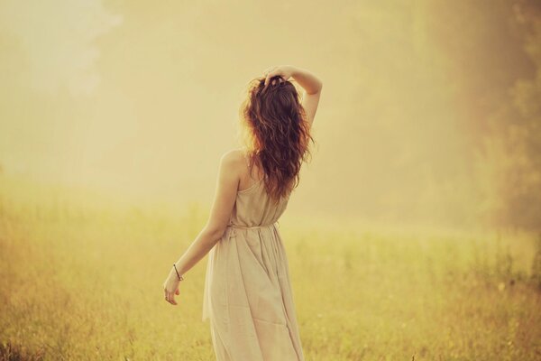 A girl standing with her back against the background of nature