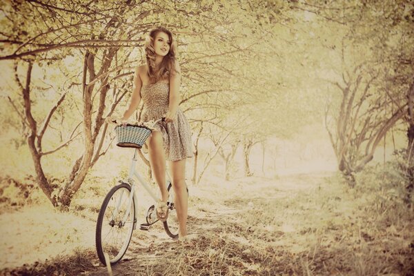Chica en un vestido de luz en una bicicleta con una cesta