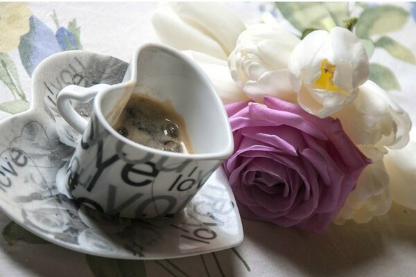 Tazza di caffè con bouquet di rose sul tavolo