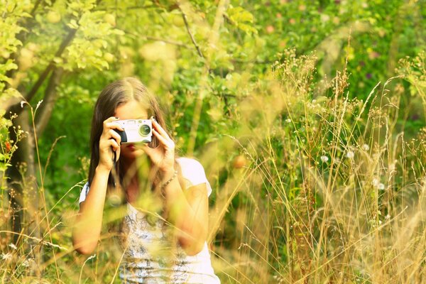 Ragazza nel campo con la macchina fotografica