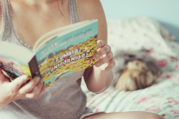 Mädchen auf dem Bett mit einem Buch in der Hand