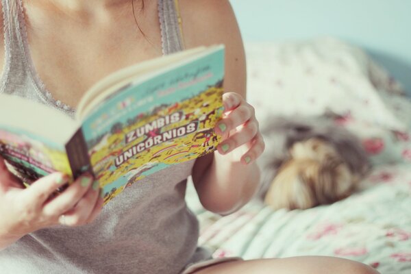 Chica en la cama con un libro en la mano