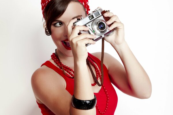 Belle fille en rouge, avec des appareils photo dans les mains. Style rétro moderne