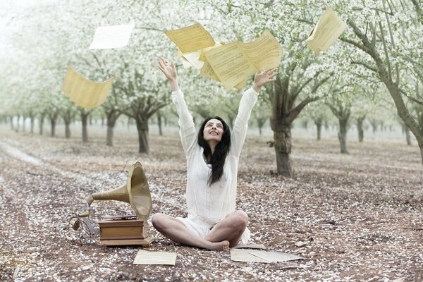 La ragazza lancia le note accanto al grammofono in giardino