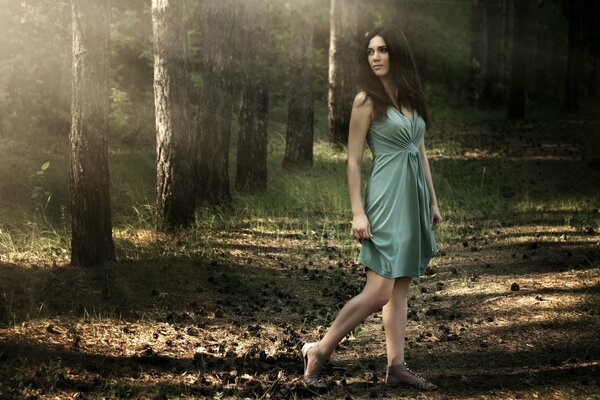 A girl in a dress on a path in the forest