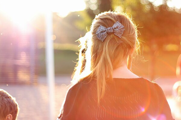Причёска девушки с бантиком в солнечных лучах