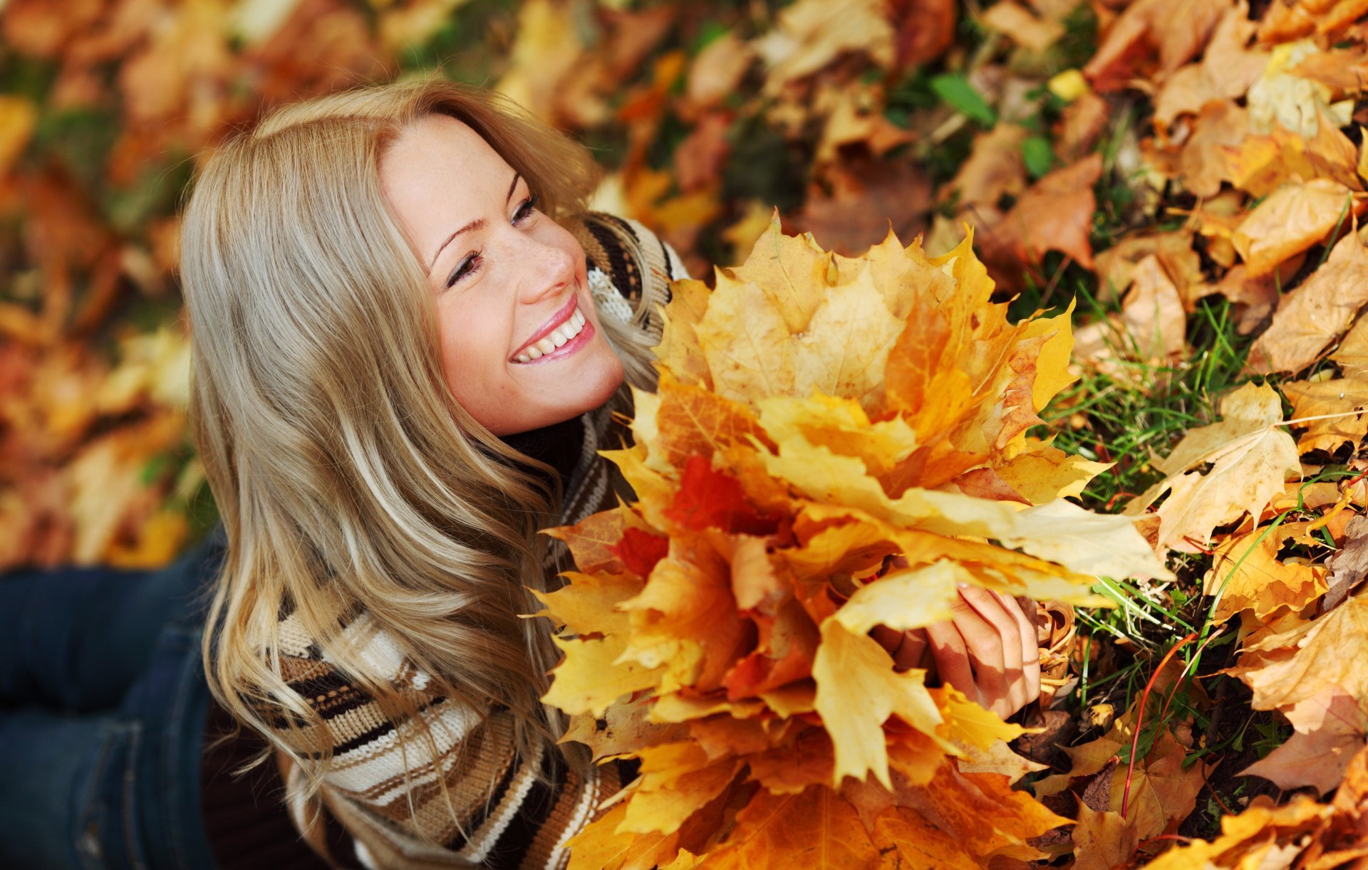 girl smile view blonde is jeans sweater autumn grass leave