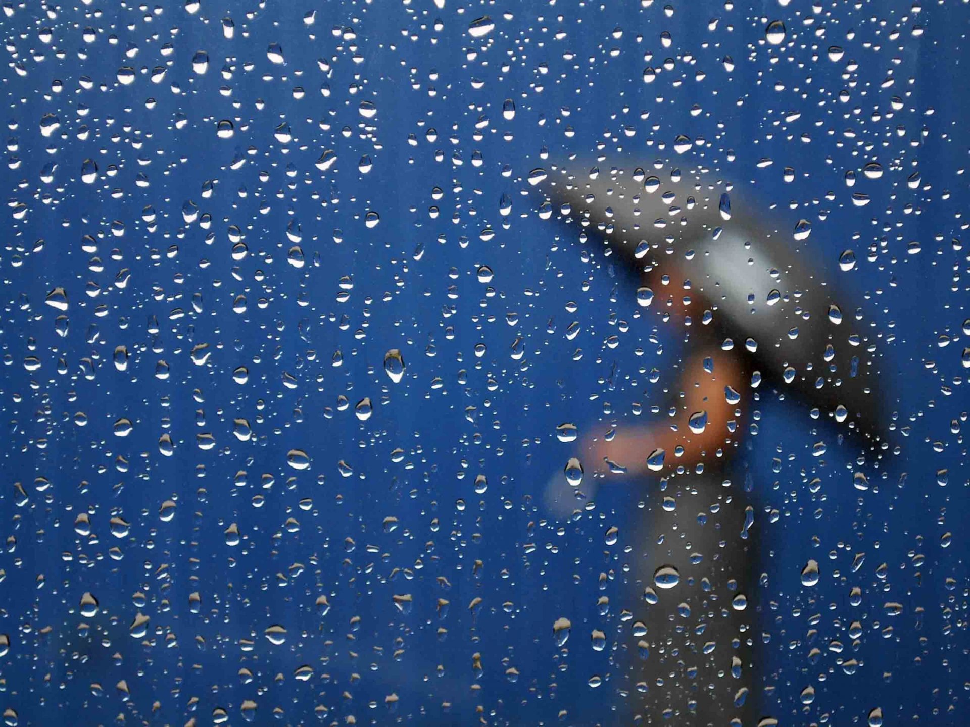 rain glass drops silhouette woman in the rain