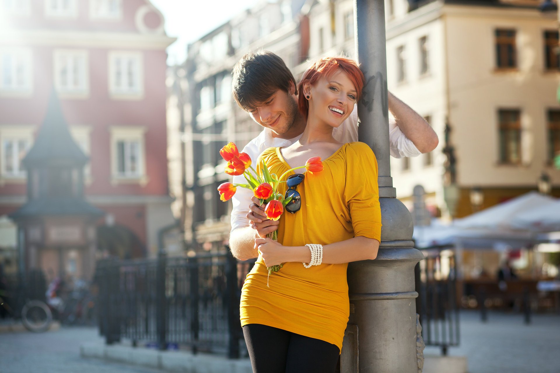 the pair girl red guy laughter smile flower tulips town fence touch sunglasses bike