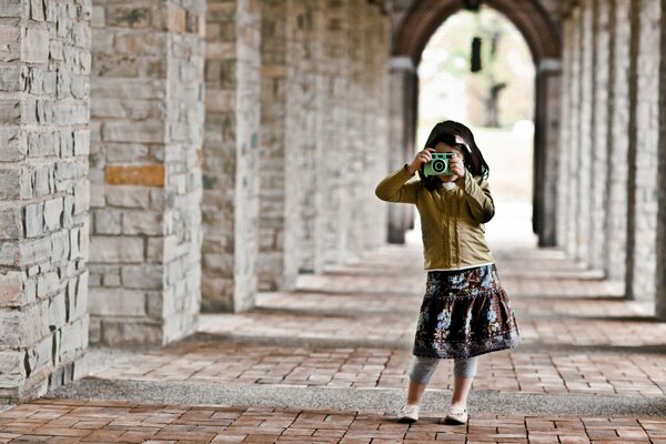 Niña fotografiando en una bóveda arqueada