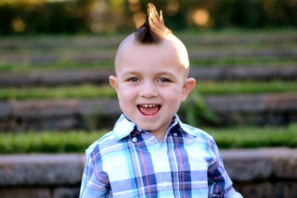 A smiling boy with a mohawk