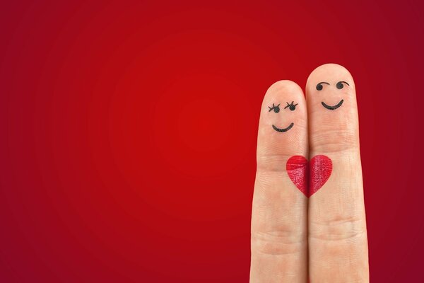 Fingers with a heart pattern and a smiling couple of emoticons a girl and a boy