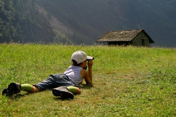 Мальчик, наблюдающий за домом в траве