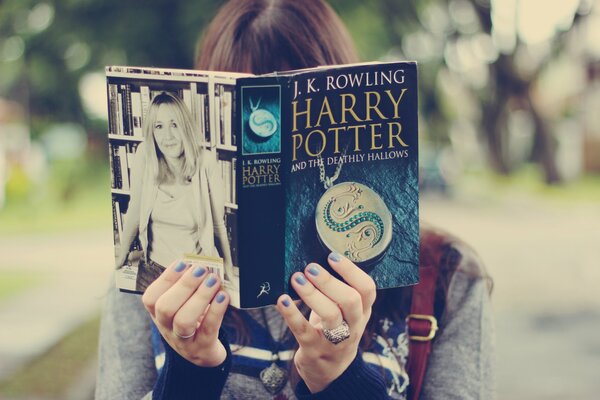 Девушка читает книгу Гарри поттер