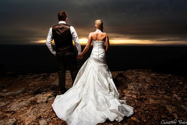 A girl in a wedding dress with a guy by the hand