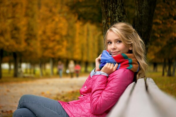 A girl on a bench with an autumn mood