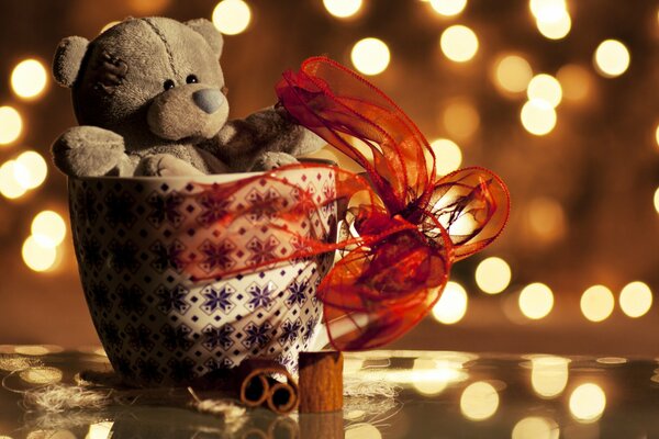 Teddy bear packed in a pot with a red gift ribbon