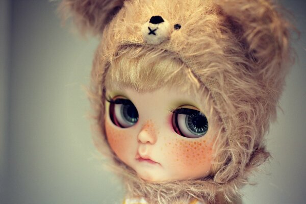 A doll in a teddy bear hood with sad eyes