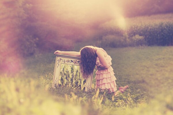 A girl in a dress in a field covered with long brown hair