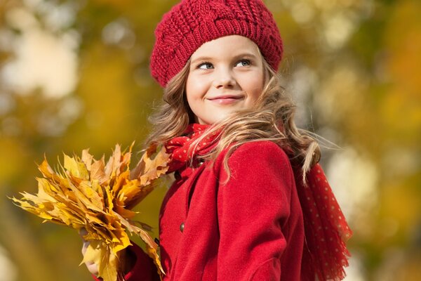 Девочка в красной одежде и желтыми листьями