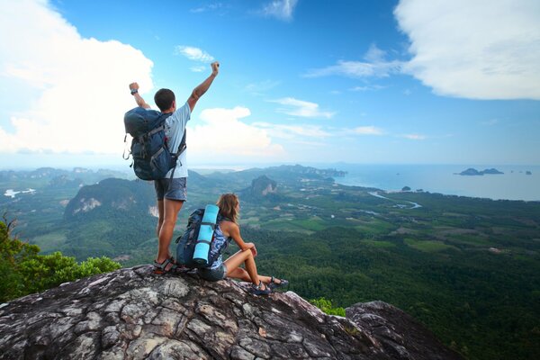 A guy and a girl. Tourists at the top with a view of the valley