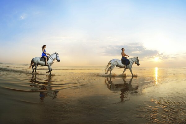 Promenade des amoureux à cheval sur le bord de la mer