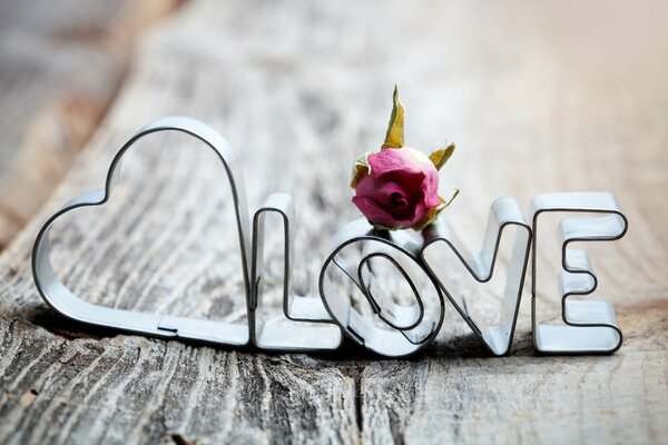 Metal inscription love on wooden boards