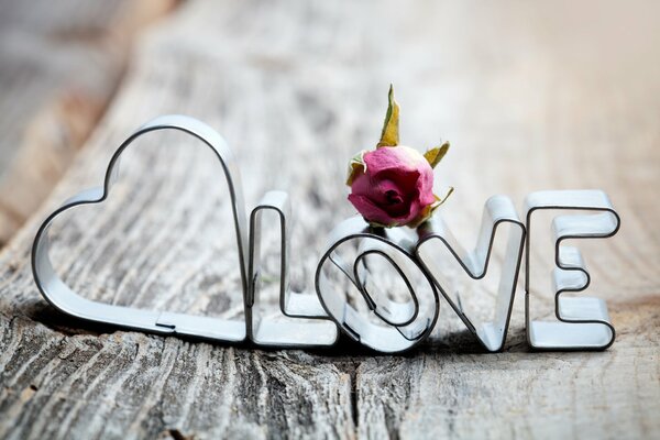 Metalowy napis miłość na drewnianych deskach