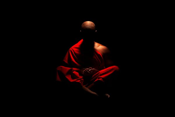 Un monje budista que medita en la oscuridad
