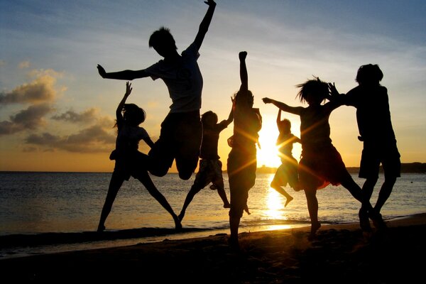 Young people on the beach at sunset