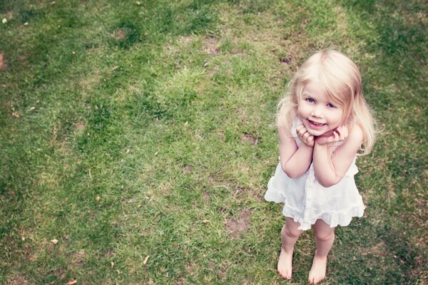 Fille avec un sourire angélique sur fond d herbe