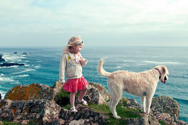 A girl with a dog on the seashore