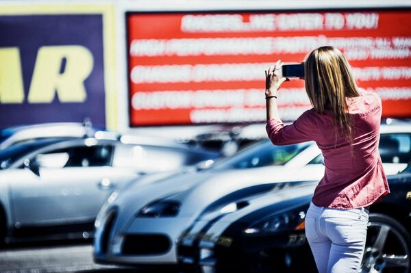 A girl takes pictures of a car