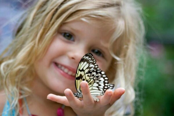 Curly-haired girl is happy with a butterfly