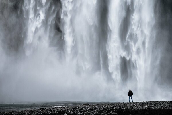 Un homme seul se tient près d une cascade avec une tête baissée