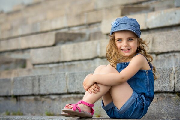 A girl in a cap smiles on the street