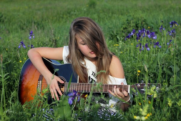 Mädchen mit Gitarre auf einer Sommerlichtung