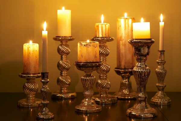 There is a candlestick on the table , candles are burning brightly